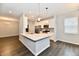 Bright kitchen with white island with sink, stainless steel appliances and wood floors at 1803 Jackson St, Fortville, IN 46040