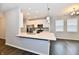Open concept kitchen with white cabinets, stainless steel appliances and wood floors at 1803 Jackson St, Fortville, IN 46040