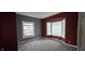 Spacious bedroom with neutral carpet, large windows, and fresh paint at 2028 George St, Anderson, IN 46016