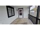 Cozy covered porch with wooden deck and black framed windows at 2028 George St, Anderson, IN 46016