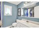 Bathroom with blue walls, a toilet, vanity with white cabinets and mirror, and a shower with blue and white curtains at 22 Point Ln, Arcadia, IN 46030