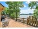 Wooden deck overlooking a serene lake, surrounded by lush greenery, with stair access to the water at 22 Point Ln, Arcadia, IN 46030