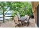 Outdoor dining set on wooden deck with beautiful lake views and lush greenery at 22 Point Ln, Arcadia, IN 46030