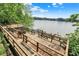 Wooden deck with stairs leading down to a tranquil lake surrounded by trees at 22 Point Ln, Arcadia, IN 46030