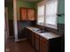 Functional kitchen featuring a stainless steel sink, wooden cabinets, and neutral countertops at 3035 Graceland Ave, Indianapolis, IN 46208
