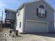 View of home exterior showing two-car garage and gravel driveway at 3036 Chase St, Indianapolis, IN 46217