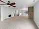 Spacious living room with a ceiling fan, fireplace, and a wall with rustic wood paneling at 3313 Capsella Ln, Indianapolis, IN 46203