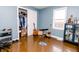 Bedroom with blue walls, hardwood floors, closet, guitars, and display cabinet at 4910 East 21St St, Indianapolis, IN 46218