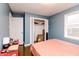 Bedroom featuring hardwood floors, blue walls, closet, and natural light from a window at 4910 East 21St St, Indianapolis, IN 46218