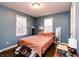 Comfortable bedroom featuring hardwood floors, natural light from two windows, and blue walls at 4910 East 21St St, Indianapolis, IN 46218