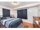 Bedroom featuring hardwood floors, dark curtains, and a comfortable bed at 518 N Emerson Ave, Indianapolis, IN 46219