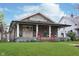 Charming home featuring a covered front porch, well-manicured lawn, and colorful landscaping, creating a welcoming curb appeal at 518 N Emerson Ave, Indianapolis, IN 46219