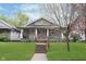 Inviting home with a covered porch, vibrant lawn, and tidy landscaping, creating a delightful first impression at 518 N Emerson Ave, Indianapolis, IN 46219