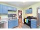 Bright kitchen featuring stainless steel appliances, blue cabinets, and gray subway tile at 518 N Emerson Ave, Indianapolis, IN 46219
