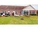 Brick home's backyard featuring a well-maintained lawn, patio, and exterior details at 5180 Dunewood Way # 57, Avon, IN 46123