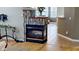 Close up of fireplace with decorative tile, view of kitchen, hardwood floors, and modern design at 5180 Dunewood Way # 57, Avon, IN 46123