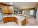 A view of the kitchen area with wooden cabinetry, laminated countertops, and an eat-in countertop at 5180 Dunewood Way # 57, Avon, IN 46123