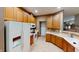 Traditional kitchen featuring wooden cabinetry, white appliances, tile flooring, and neutral walls at 5180 Dunewood Way # 57, Avon, IN 46123