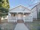Charming home with a covered front porch, white railings, and neutral-colored siding at 55 S 4Th Ave, Beech Grove, IN 46107