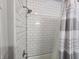 Bathroom featuring a subway-tiled shower with a chrome showerhead, complemented by a striped shower curtain at 611 W South St, Shelbyville, IN 46176
