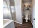 Bright bathroom featuring a toilet, walk-in shower, and shelves with decorative items at 611 W South St, Shelbyville, IN 46176