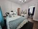 Cozy bedroom featuring a queen-sized bed, decorative pillows, a vanity, and an open doorway to the dining room at 611 W South St, Shelbyville, IN 46176