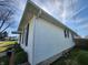Side view of a charming home showing vinyl siding, windows, and trimmed shrubbery at 611 W South St, Shelbyville, IN 46176