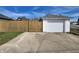 Attached garage with a wide driveway and adjacent wooden fence for added privacy at 611 W South St, Shelbyville, IN 46176