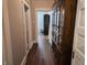 Hallway with wood floors, an ornate cabinet, and doorways leading to other rooms at 611 W South St, Shelbyville, IN 46176