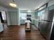 Well-lit kitchen boasts light green cabinets, stainless steel refrigerator, and modern appliances at 611 W South St, Shelbyville, IN 46176