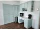 Kitchen with light green cabinets, integrated appliances, and vintage-style hardware at 611 W South St, Shelbyville, IN 46176
