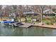 Lakefront homes offer multiple decks, a lakeside dock, and mature trees surrounding manicured lawn at 6290 Grouse Dr, Nineveh, IN 46164