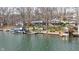 Lakefront homes offer multiple decks, a lakeside dock, and mature trees surrounding manicured lawn at 6290 Grouse Dr, Nineveh, IN 46164