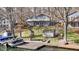Lakefront home boasts multiple decks, a lakeside dock, and mature trees surrounding manicured lawn at 6290 Grouse Dr, Nineveh, IN 46164