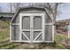 Close-up of the shed, featuring a gray exterior, white trim, and double doors at 6290 Grouse Dr, Nineveh, IN 46164