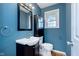 Cozy blue bathroom featuring a vanity, toilet, and window at 6407 Brokenhurst Rd, Indianapolis, IN 46220