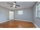 Bright bedroom features hardwood floors, neutral paint, ceiling fan, and ample natural light at 6407 Brokenhurst Rd, Indianapolis, IN 46220
