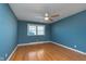 Bedroom with hardwood floors, neutral walls, ceiling fan, and natural light at 6407 Brokenhurst Rd, Indianapolis, IN 46220