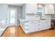 Bright kitchen with white cabinets, stainless steel appliances, and hardwood floors at 6407 Brokenhurst Rd, Indianapolis, IN 46220