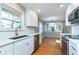 Renovated kitchen with hardwood floors, stainless appliances, white cabinets and tile backsplash at 6407 Brokenhurst Rd, Indianapolis, IN 46220