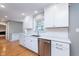 Bright kitchen with white cabinets, stainless steel appliances, hardwood floors and updated backsplash at 6407 Brokenhurst Rd, Indianapolis, IN 46220