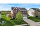 Beautifully landscaped two-story home with a brick facade, green lawn, and spacious driveway at 6862 School Branch Dr, Brownsburg, IN 46112