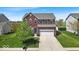 Charming two-story red brick home with a well-manicured lawn and attached two-car garage at 6862 School Branch Dr, Brownsburg, IN 46112