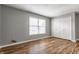 A bedroom with hardwood floors, neutral walls, double closet, and a large window at 7616 Newport Bay E Dr, Indianapolis, IN 46240