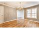 Bright dining room with a chandelier, wood floors, and natural light from windows at 7616 Newport Bay E Dr, Indianapolis, IN 46240