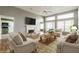 Bright living room with fireplace, ceiling fan, hardwood floors, and neutrally colored furniture at 7616 Newport Bay E Dr, Indianapolis, IN 46240