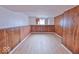 A spacious basement room with wood paneling and laminate floors at 7733 Opelika Ct, Indianapolis, IN 46217