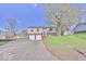 Split-level home with an attached two-car garage and a well-manicured lawn at 7733 Opelika Ct, Indianapolis, IN 46217