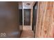 Hallway with wood paneling and neutral flooring, showcasing multiple doors at 7733 Opelika Ct, Indianapolis, IN 46217