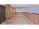 Spacious room with wood paneling, laminate floors, and a ceiling fan at 7733 Opelika Ct, Indianapolis, IN 46217